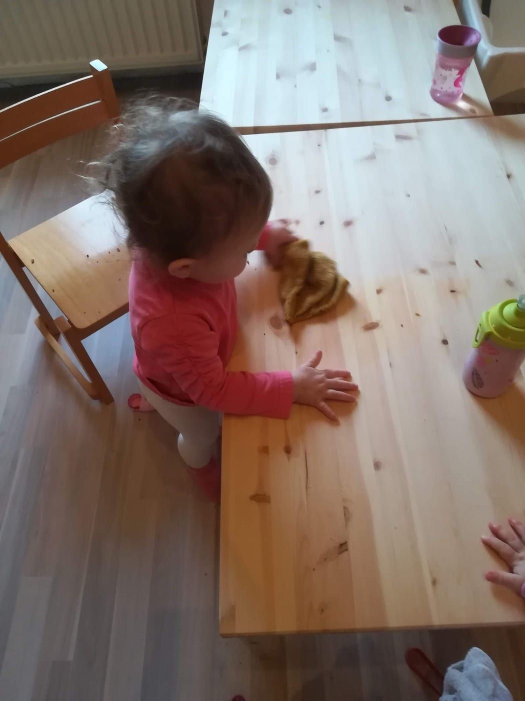 Kind am Holztisch mit Spielzeug, von oben