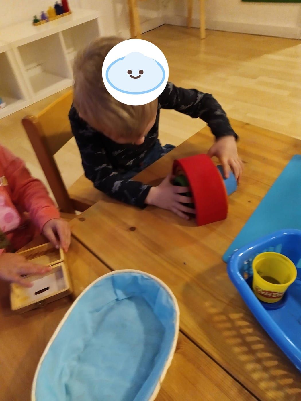 Kind spielt konzentriert mit Holzspielzeug