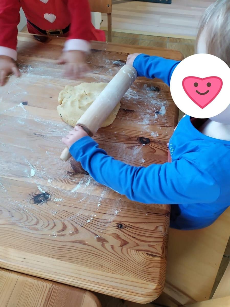 Kind rollt Teig mit dem Nudelholz